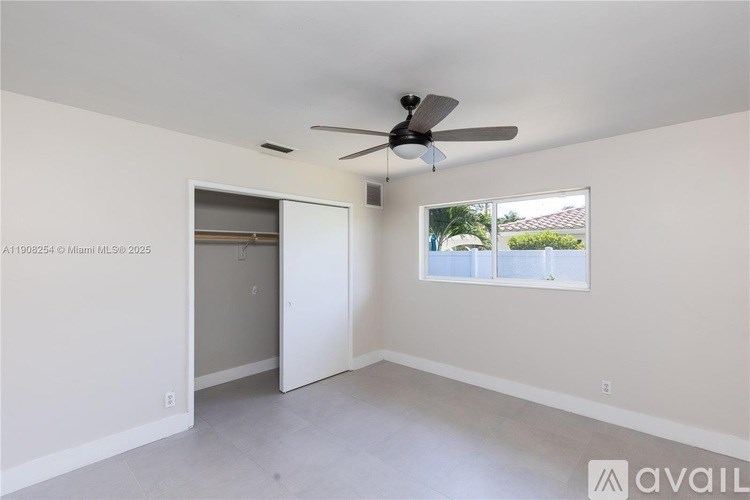 A room with a ceiling fan and a sliding door.