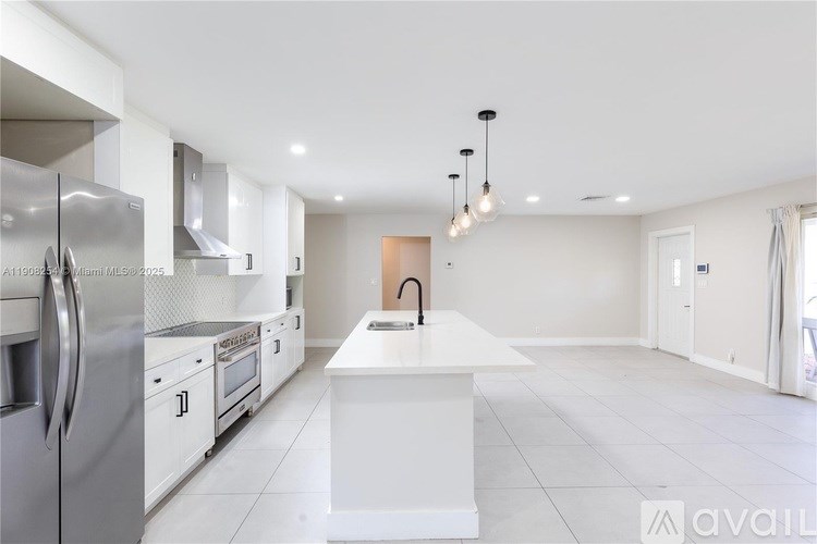 A modern kitchen with stainless steel appliances and white cabinetry.