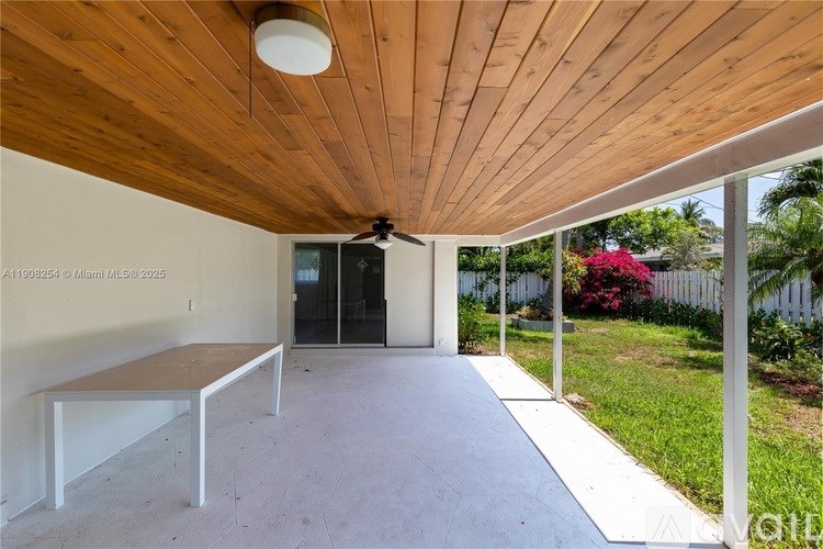 A wooden ceiling with a fan and a long white bench.