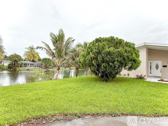 A house with a green lawn and a tree in front of it.