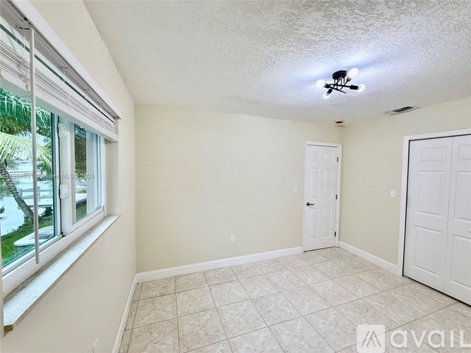 A room with a ceiling fan and two doors.