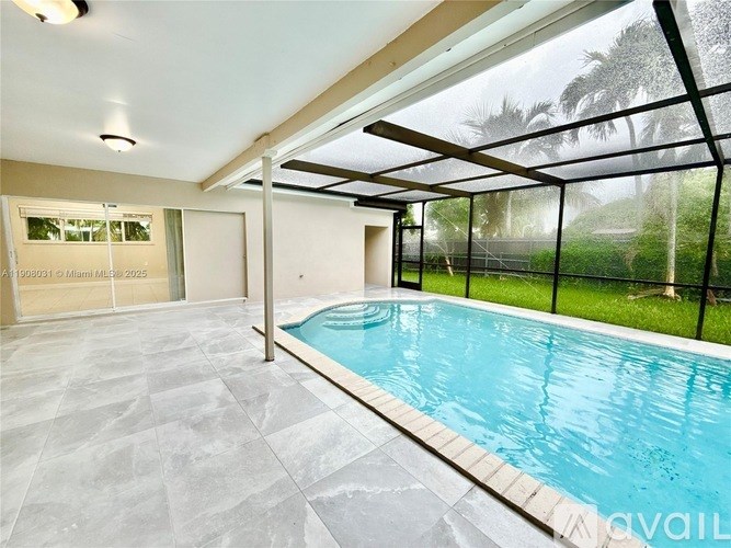 A swimming pool inside a house with a glass wall.