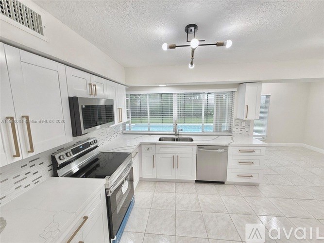 A kitchen with white cabinets and a black stove top oven.