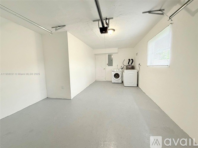 A spacious room with a washing machine and dryer in it.