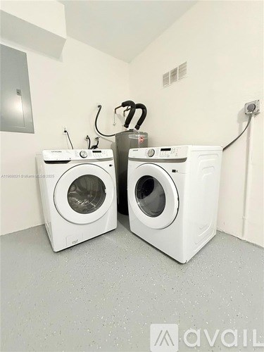 Two white front loading washing machines in a laundry room.