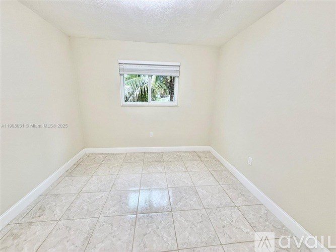 A room with a window and tiled flooring.