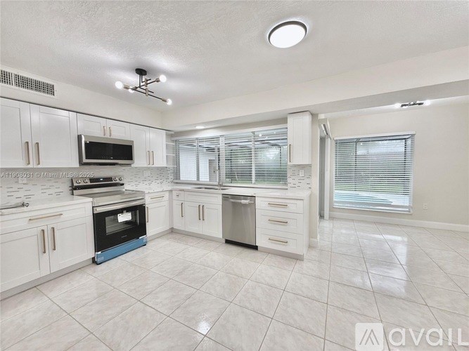 A kitchen with white cabinets and a blue oven.