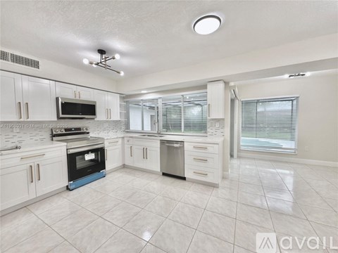 A kitchen with white cabinets and a blue oven.