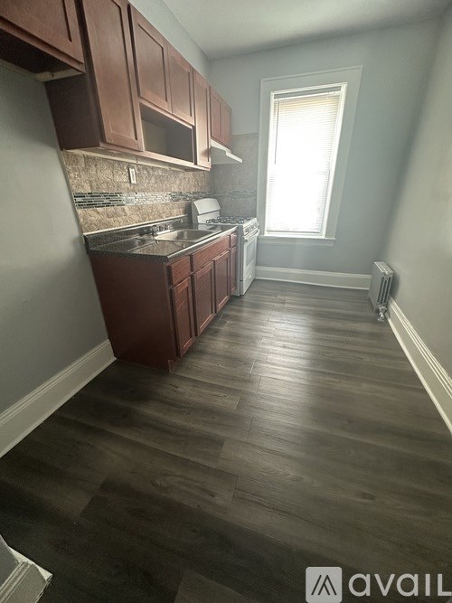 A kitchen with wooden cabinets and a window.