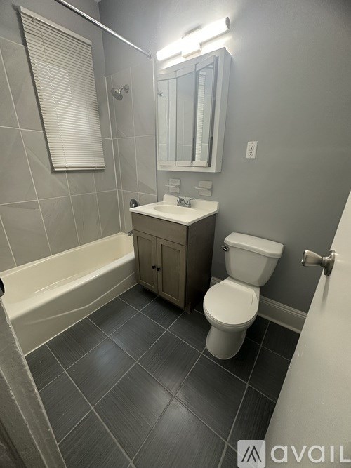 A bathroom with a toilet, sink, and bathtub.