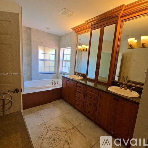 A bathroom with a tub, sink, and mirror.