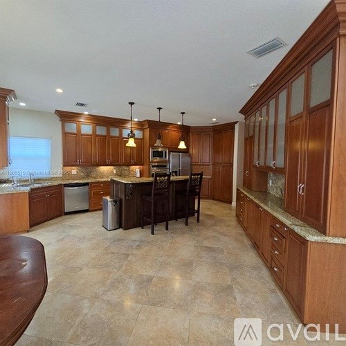 A kitchen with wooden cabinets and a marble countertop.