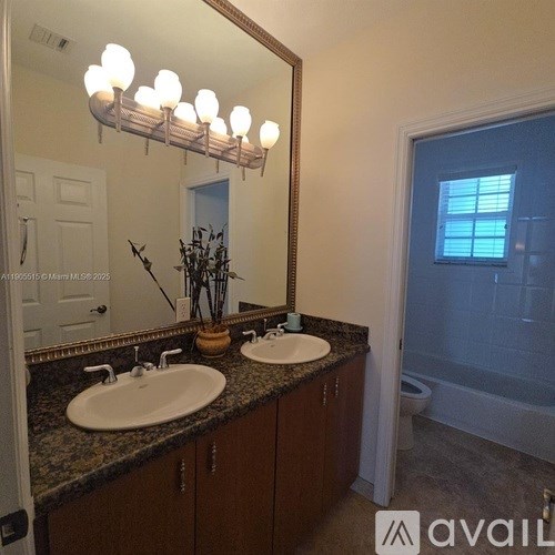 A bathroom with two sinks and a large mirror.