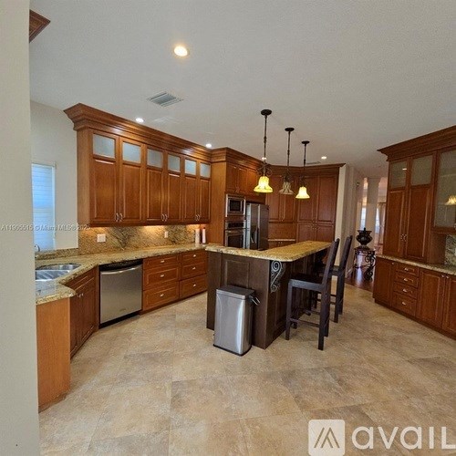 A kitchen with wooden cabinets and a large island.