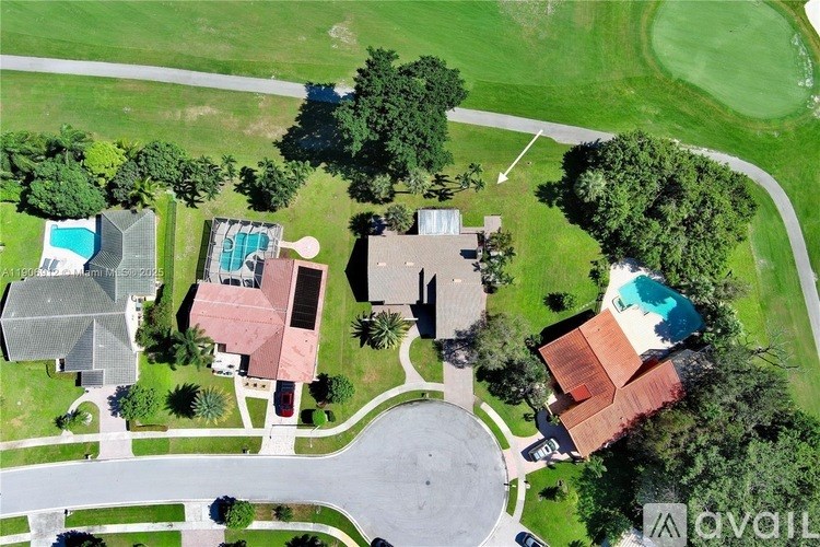 A bird's eye view of a residential area with houses and swimming pools.