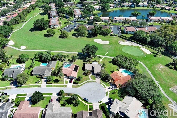 A bird's eye view of a residential area with a golf course.