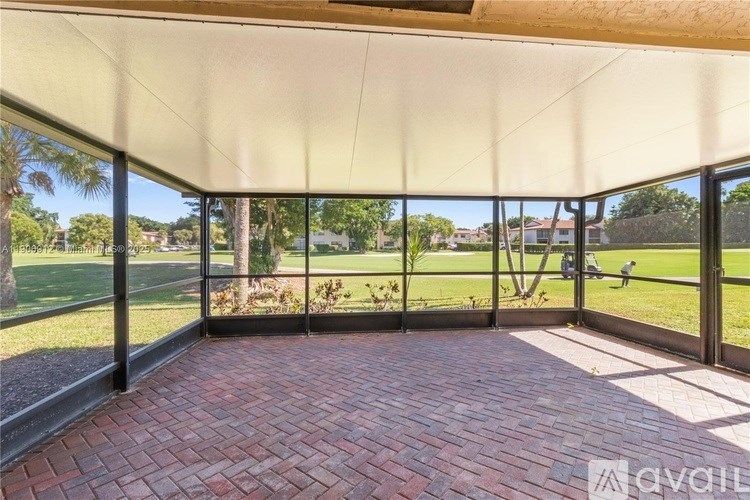 A covered patio area with a brick floor and a white ceiling.
