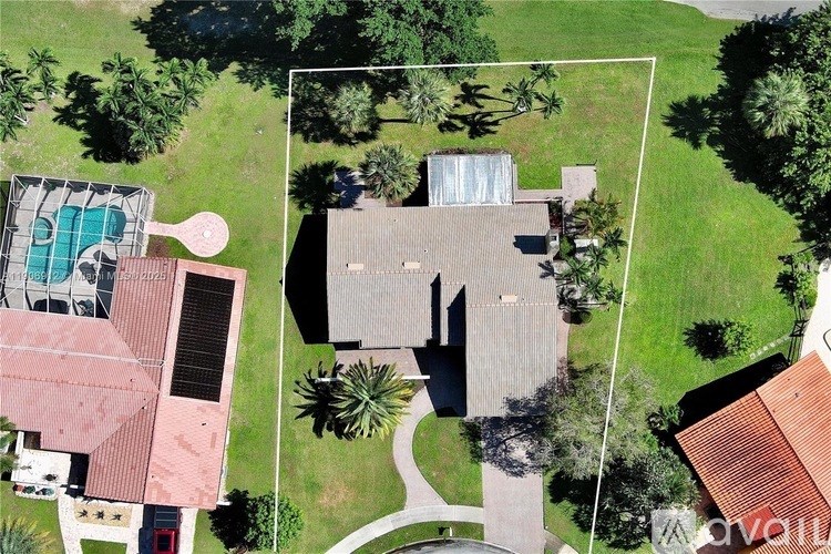 A bird's eye view of a house with a pool and a tennis court.