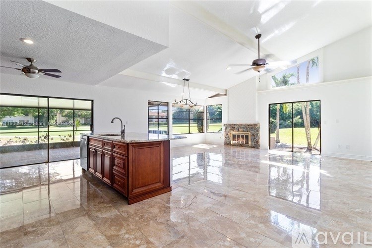 A spacious kitchen with a marble floor and a wooden island.
