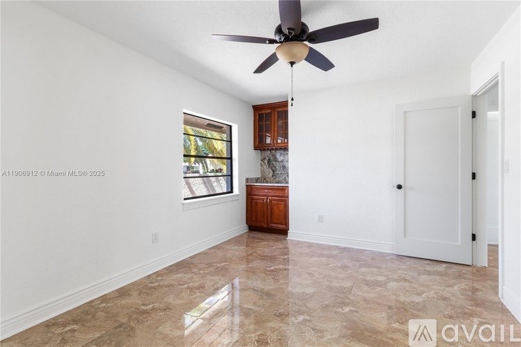 A room with a ceiling fan and a marble floor.