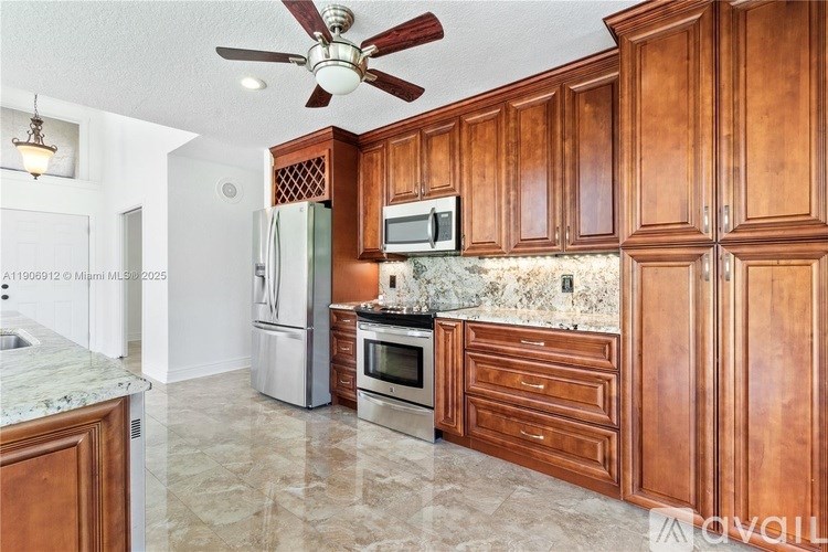 A kitchen with wooden cabinets and a marble countertop.