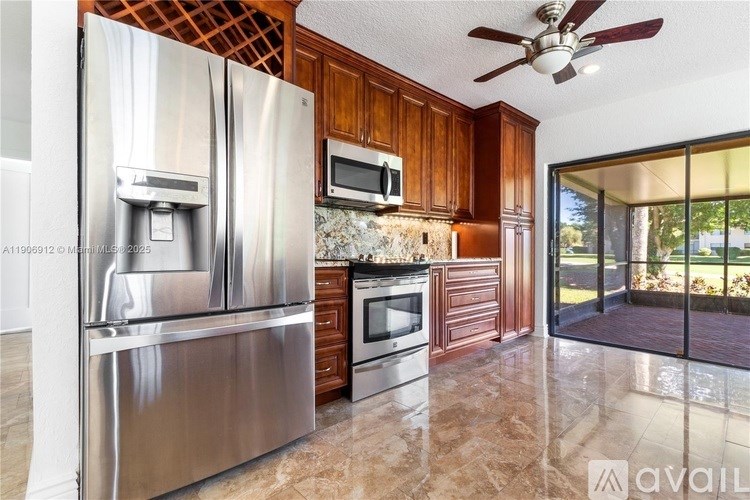 A modern kitchen with a stainless steel refrigerator, microwave, and oven.