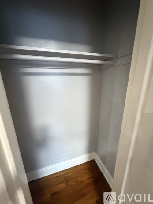 A white wall with a wooden floor and a white door.