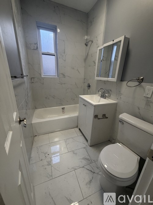 A bathroom with a toilet, sink, and tub.