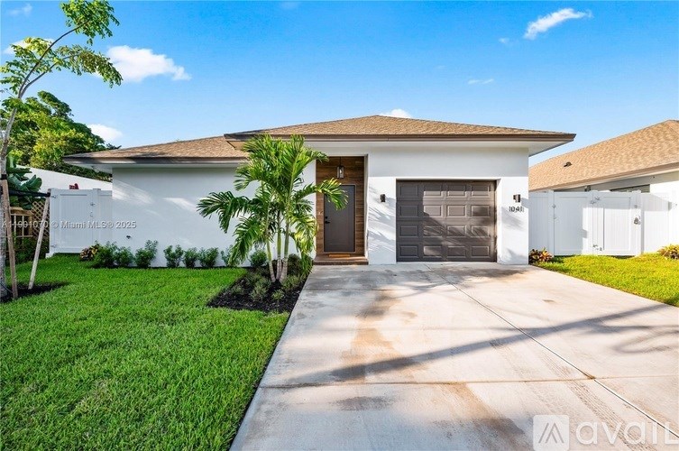 A white house with a brown roof and a garage door.