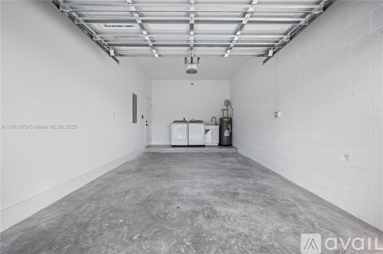 A large, empty industrial space with a concrete floor and white walls.