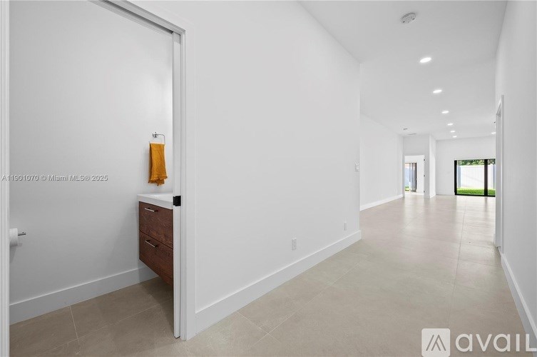 A room with a white wall and a door with a handle.