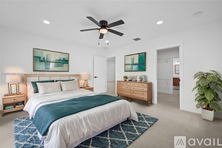 A bedroom with a large bed and a ceiling fan.