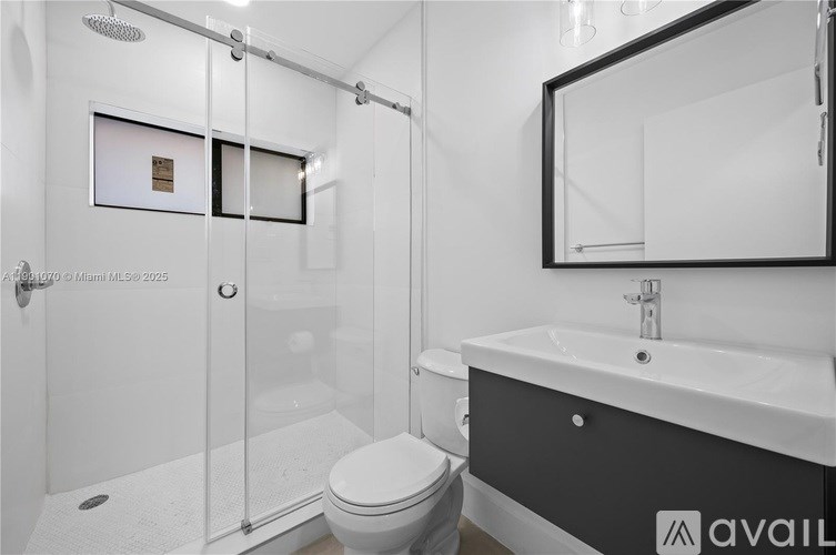 A modern bathroom with a toilet, sink, and shower.