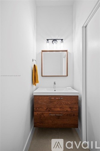 A bathroom with a sink, mirror and wooden drawers.