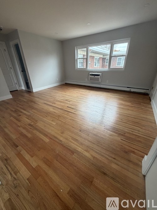 A room with wooden flooring and a window.
