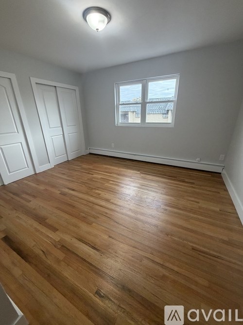 A room with wooden flooring and a window.