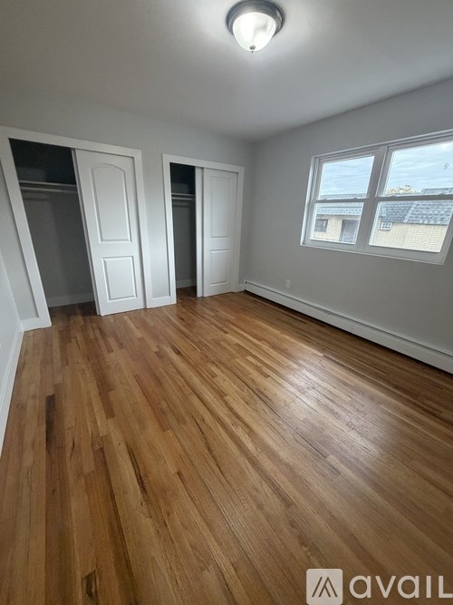 A room with wooden flooring and white walls.