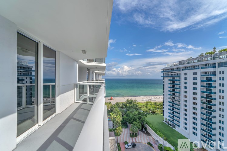 A view of a balcony overlooking a beach from a high rise building.