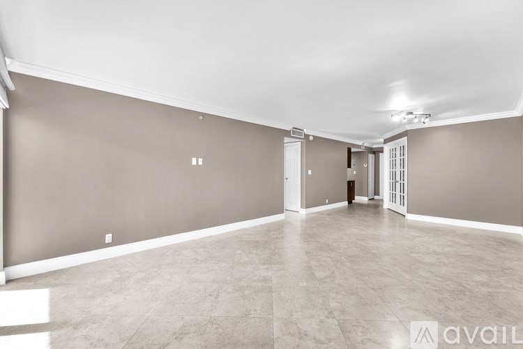 A spacious room with a marble floor and neutral walls.