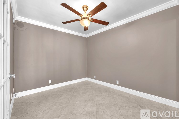 A room with a ceiling fan and carpeted floor.
