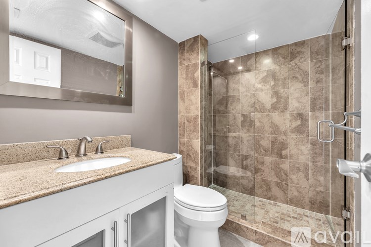 A bathroom with a toilet, sink, and shower.