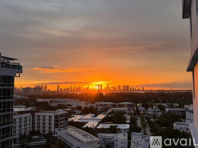 A sunset view from a high-rise building overlooking a city skyline.