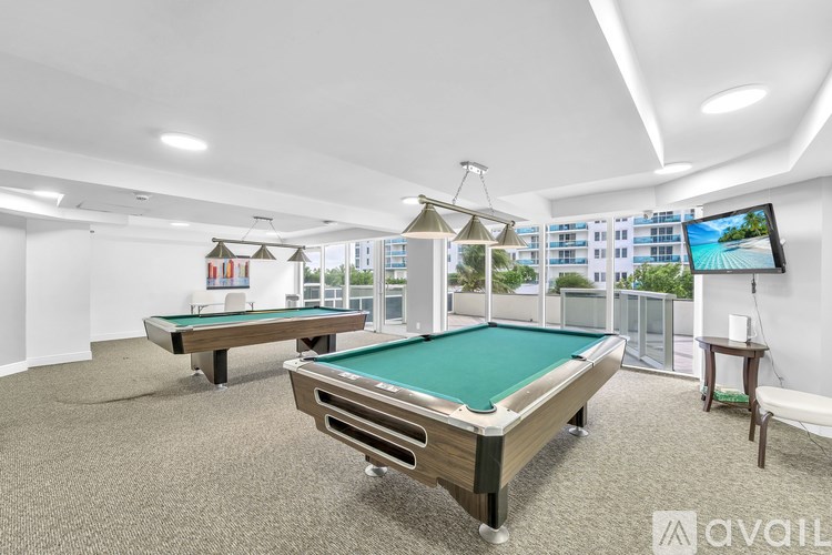 A room with a pool table and a television.