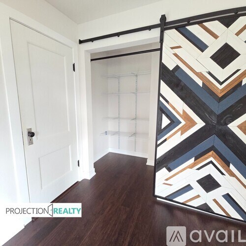 A room with a wooden floor and a white door.