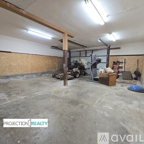 A large empty room with a ladder and some construction materials.