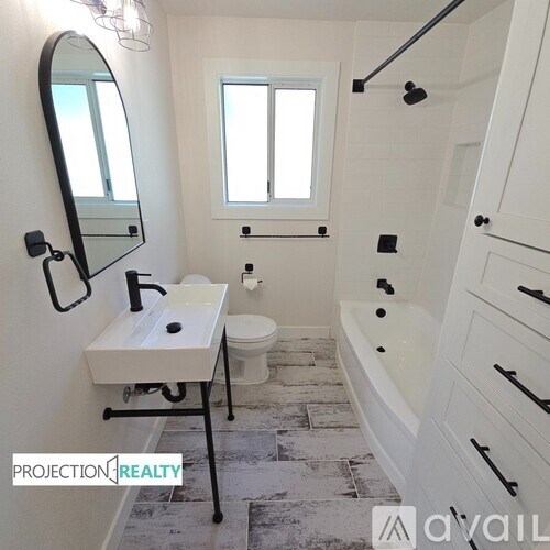 A bathroom with a toilet, sink, and bathtub.