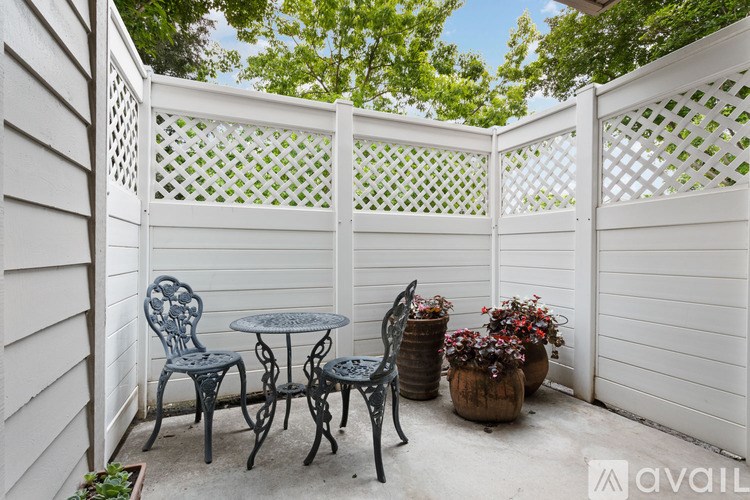 A white lattice fence encloses a small table and chairs.