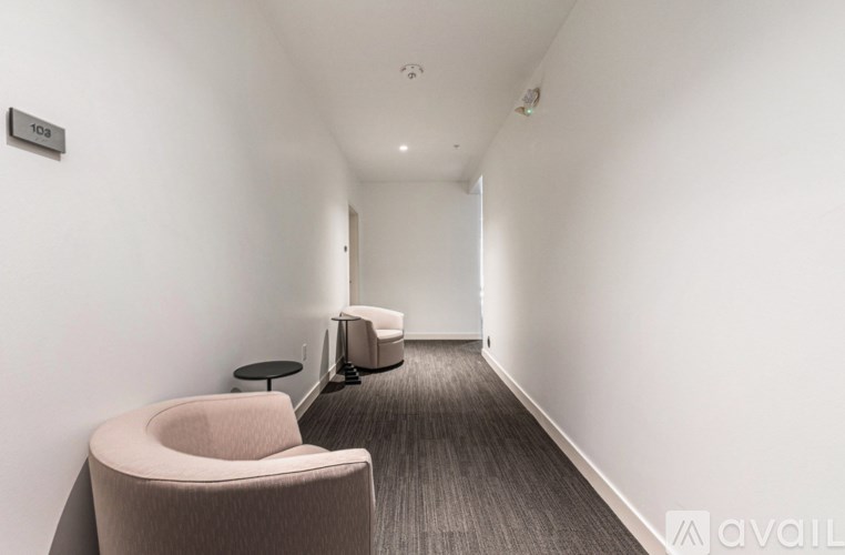 A hallway with a chair and a suitcase.