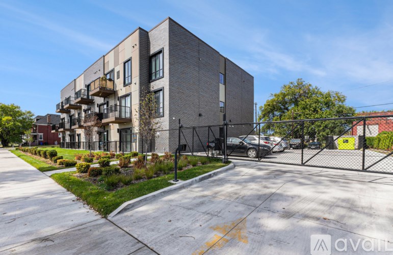 A modern apartment building with a parking lot in front.