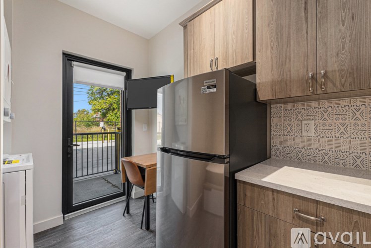 A kitchen with a refrigerator, cabinets, and a washing machine.